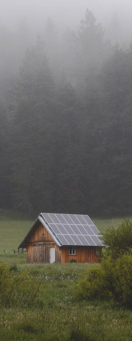 Remote cabin equipped with rooftop solar panels, illustrating off-grid solar power system design, independent electricity generation, and battery energy storage applications.